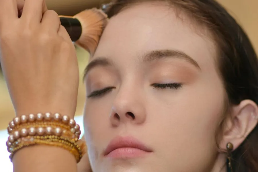 A girl getting foundation blended into her face.